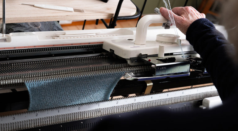 Tekstildesigner Bodil Zahl Grytten i Knitmyway ved håndstrikkemaskinen. Foto: Nilsson Cinematics