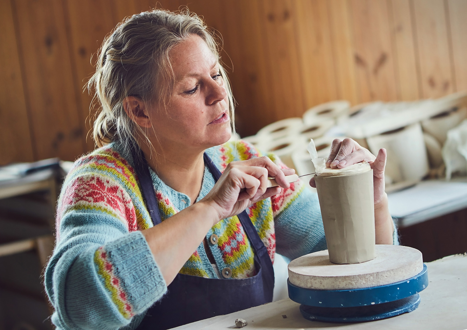Keramiker Britt i arbeid med krus i steingodsleire, Britt Bakkens Keramikk. Foto: Cathrine Dokken, Kreativ Strek