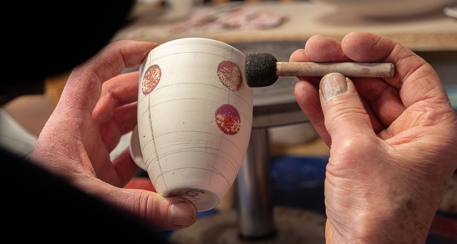 Dekorering for hånd av krus i steingodsleire ved keramiker Esther Schenker i Valdres Keramikk Atelier. Foto: Nilsson Cinematics