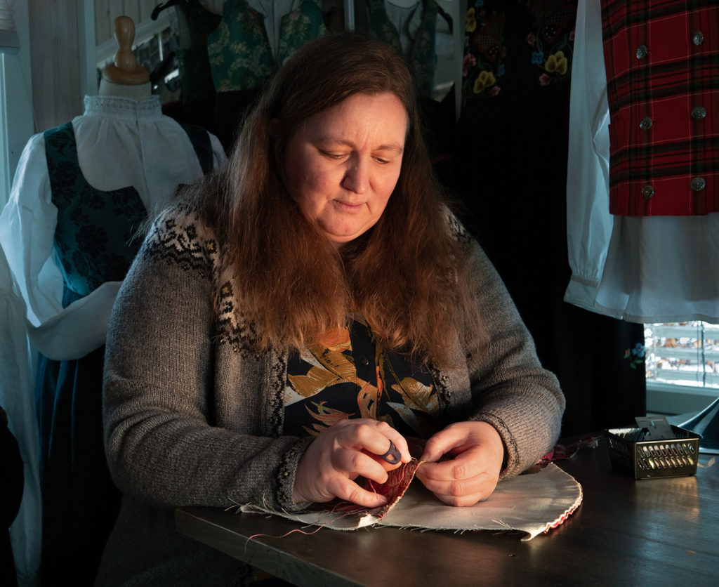Bunadshåndverker Mariann Hagen Tømterud i arbeid med håndsøm til bunad. Foto: Nilsson Cinematics