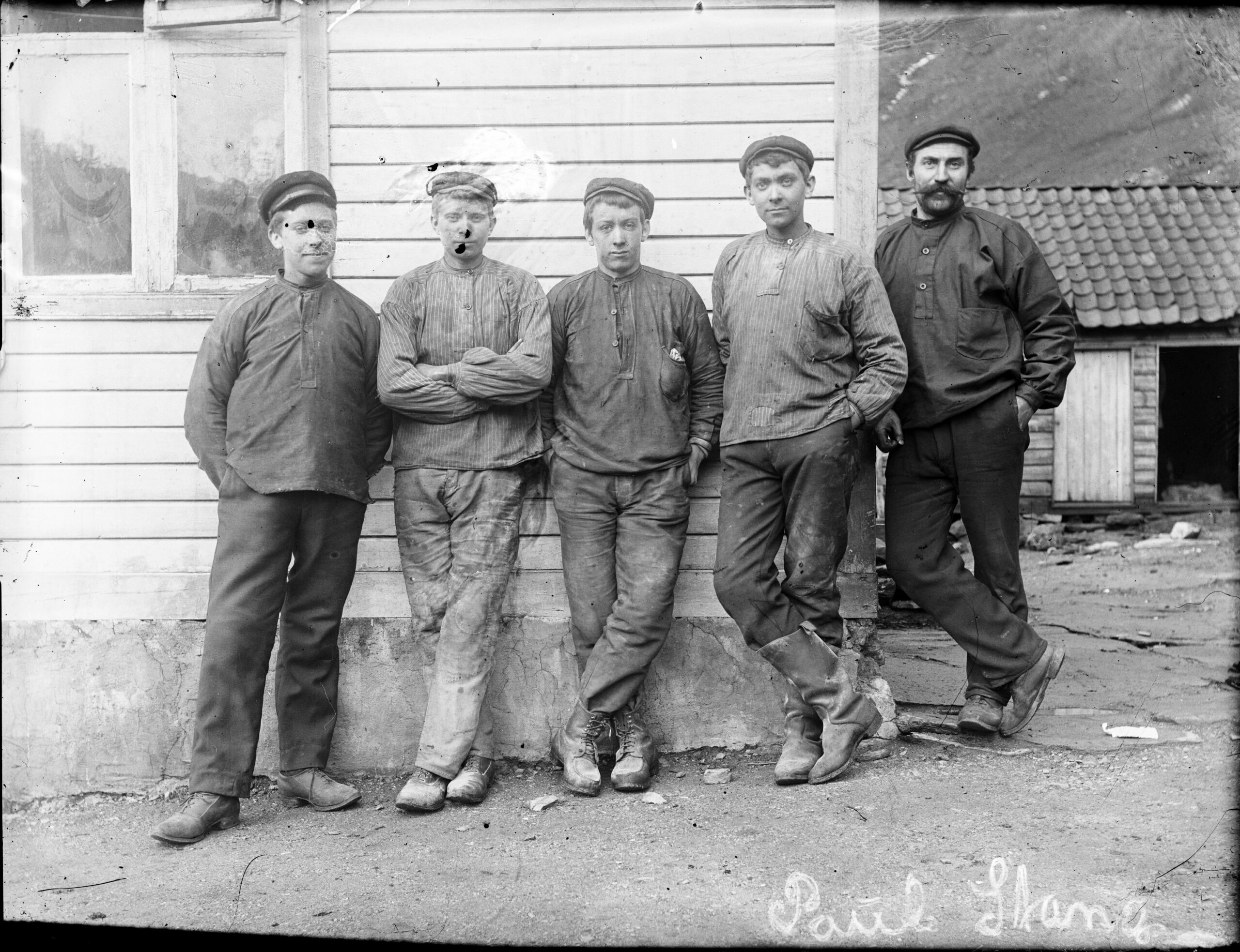 Skiftarbeidere ved aluminiums­fabrikken i Stongfjorden kledd i busseruller med og uten striper i 1908. Foto: Paul Stang/Fylkesarkivet