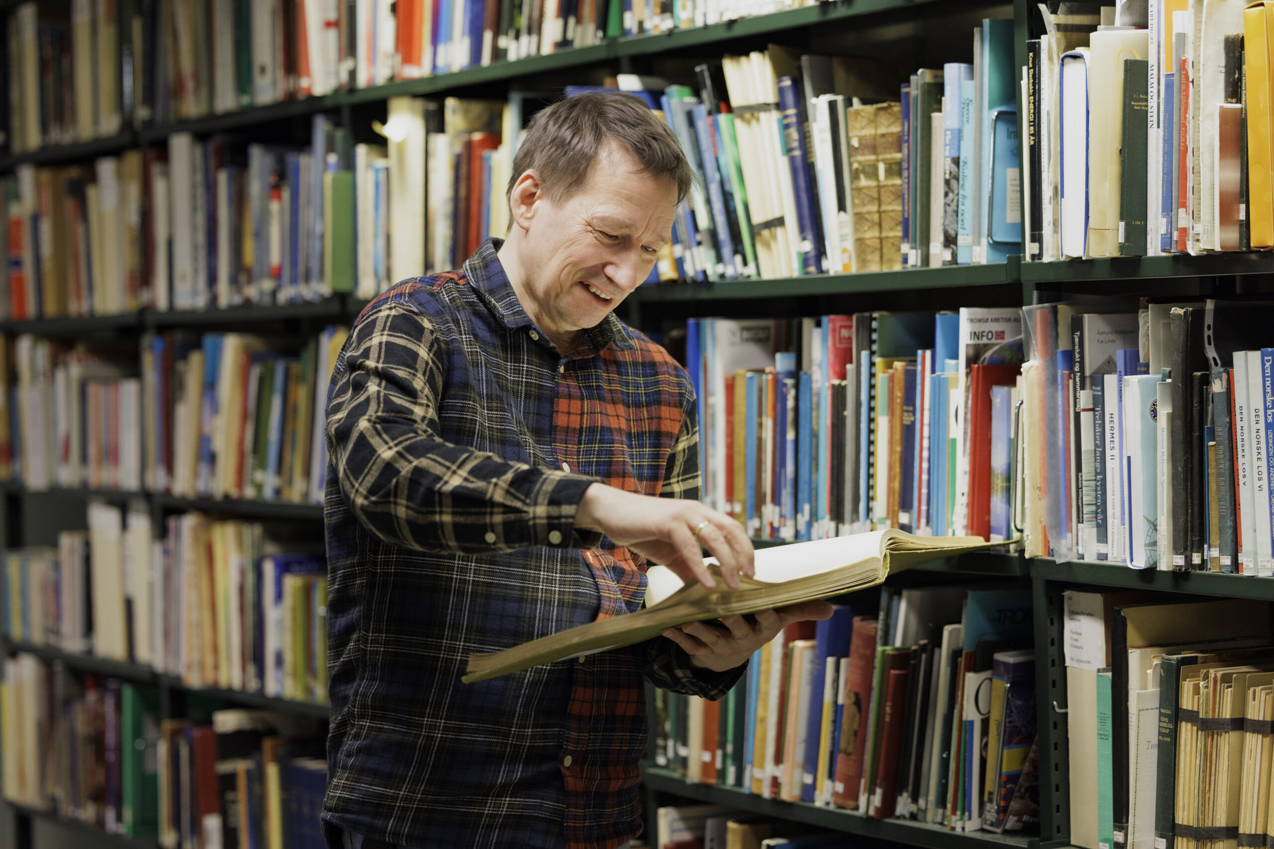 Somby jobber som IT-rådgiver på Tromsø bibliotek og byarkiv. I Lokalhistorisk samling er det 150 år gamle bøker, fylt med bilder fra Sápmi. Foto: Marius Fiskum