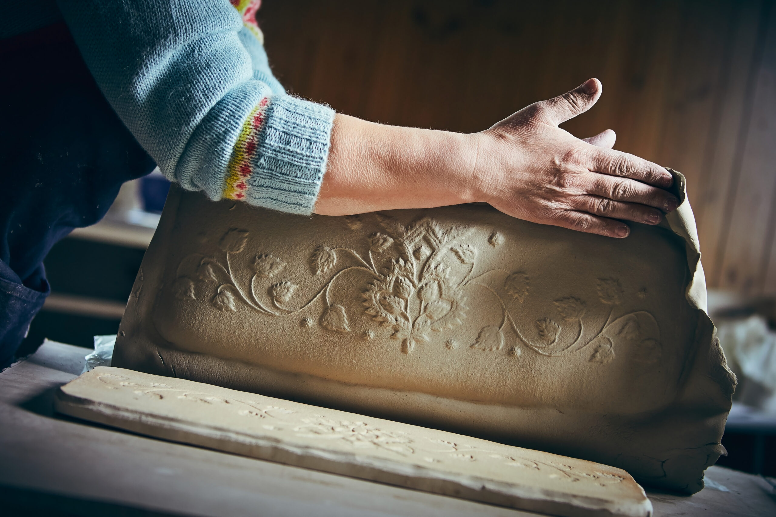 Keramiker Britt Bakken i arbeid med mønstertrykk i steingodsleire. Foto: Cathrine Dokken