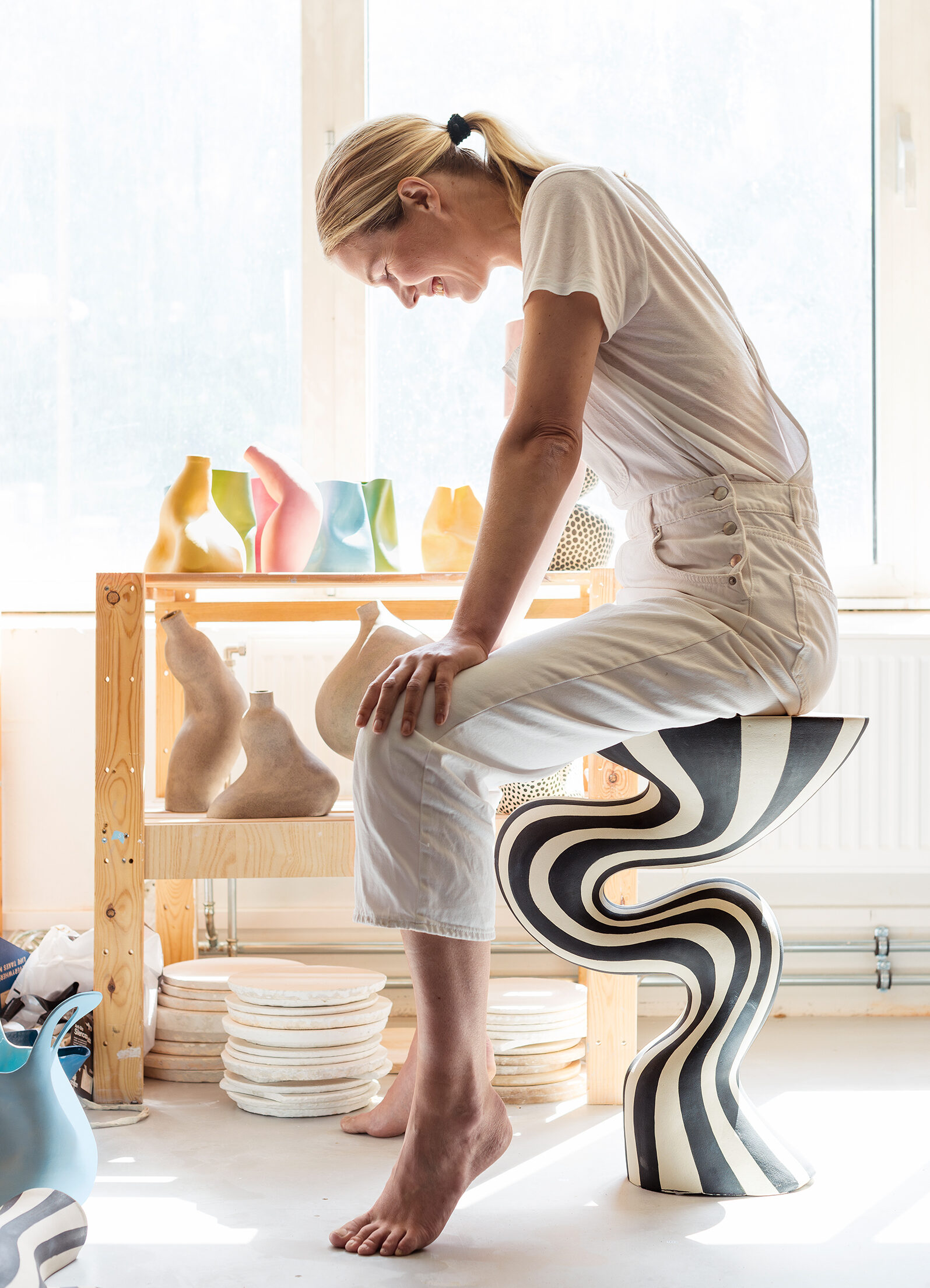 – Leire er mye sterkere enn man tror, sier Johanne Birkeland, sittende på hennes største keramikkprodukt til nå, bordet «Fåvne». Foto: Astrid Waller
